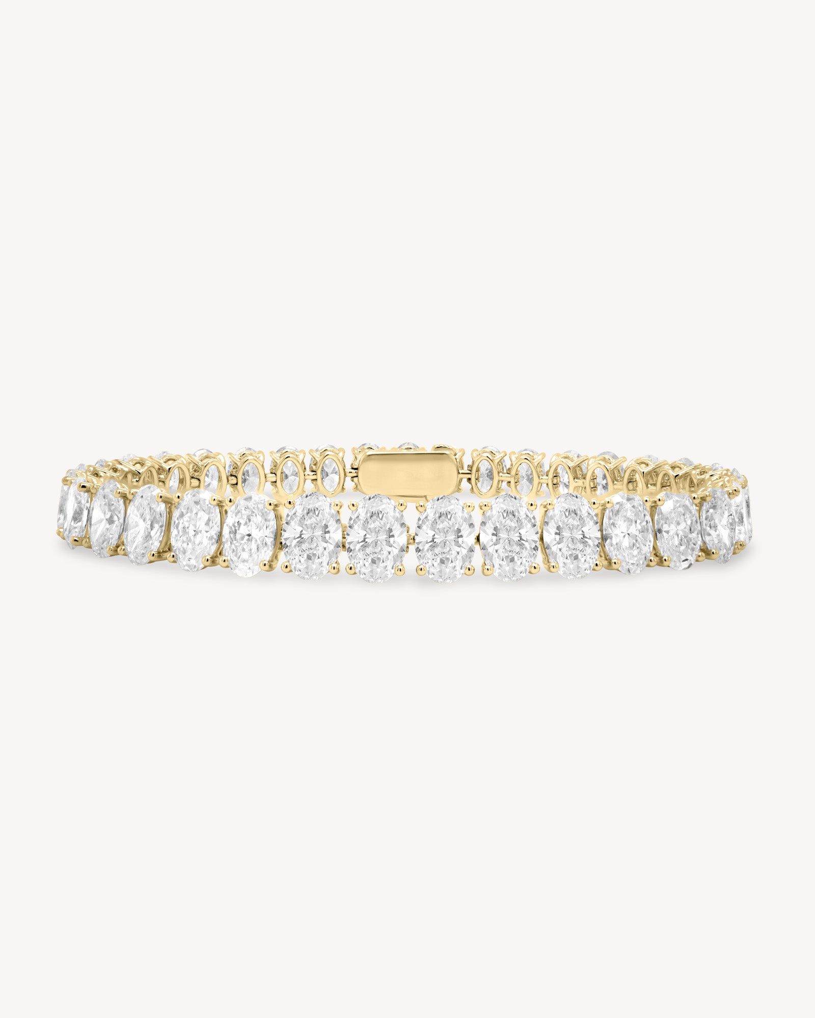 Oval cut diamond tennis bracelet in four-prong setting in yellow gold