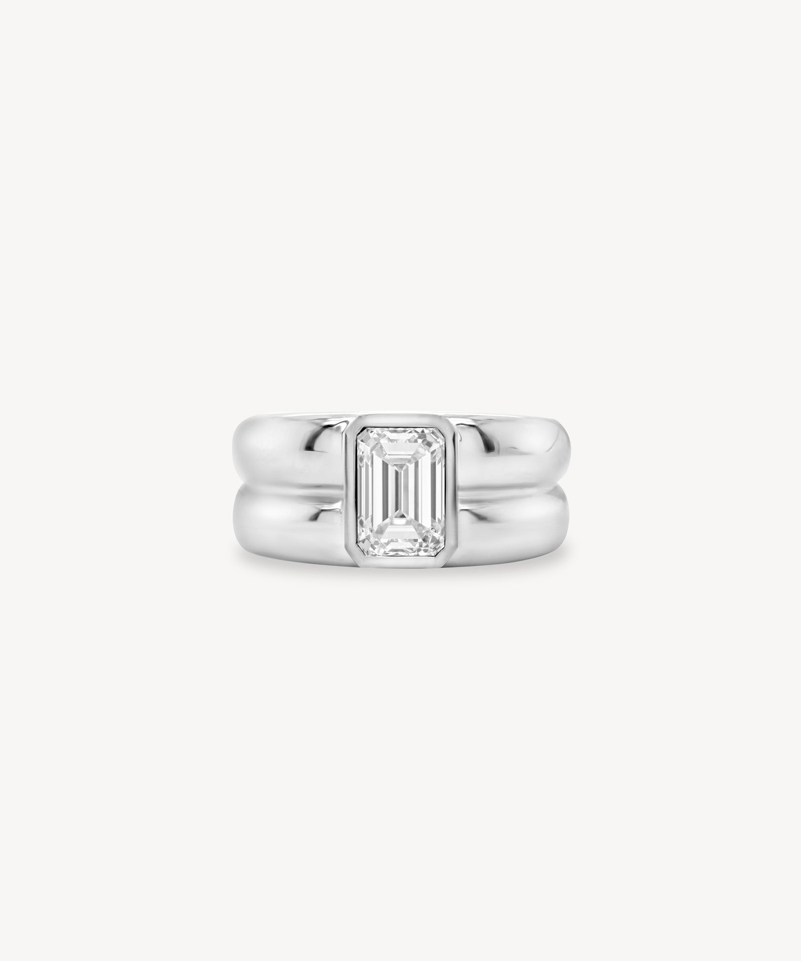 Emerald Cut diamond double gold band ring in 18K white gold set against a white background