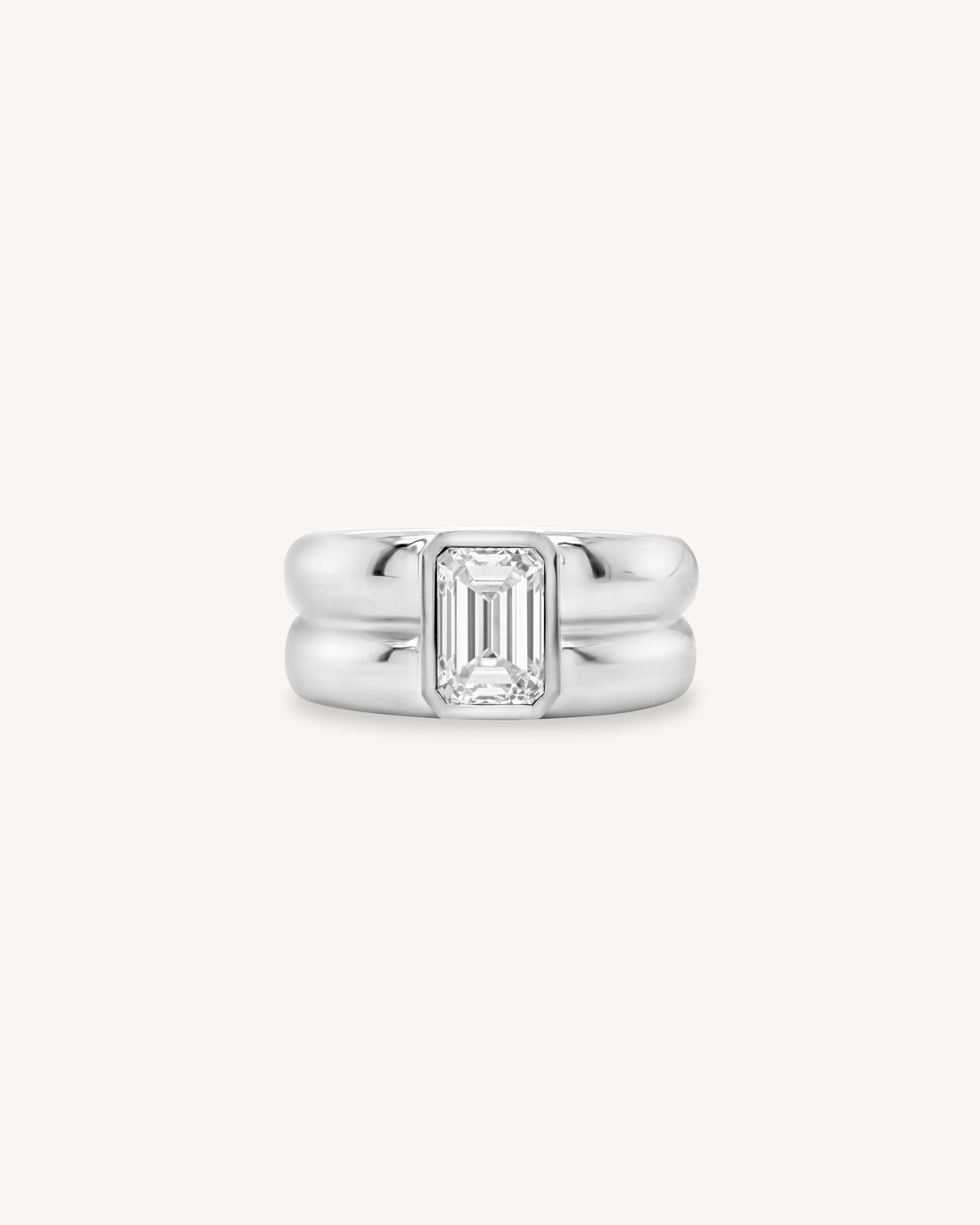 Emerald Cut diamond double gold band ring in 18K white gold set against a white background
