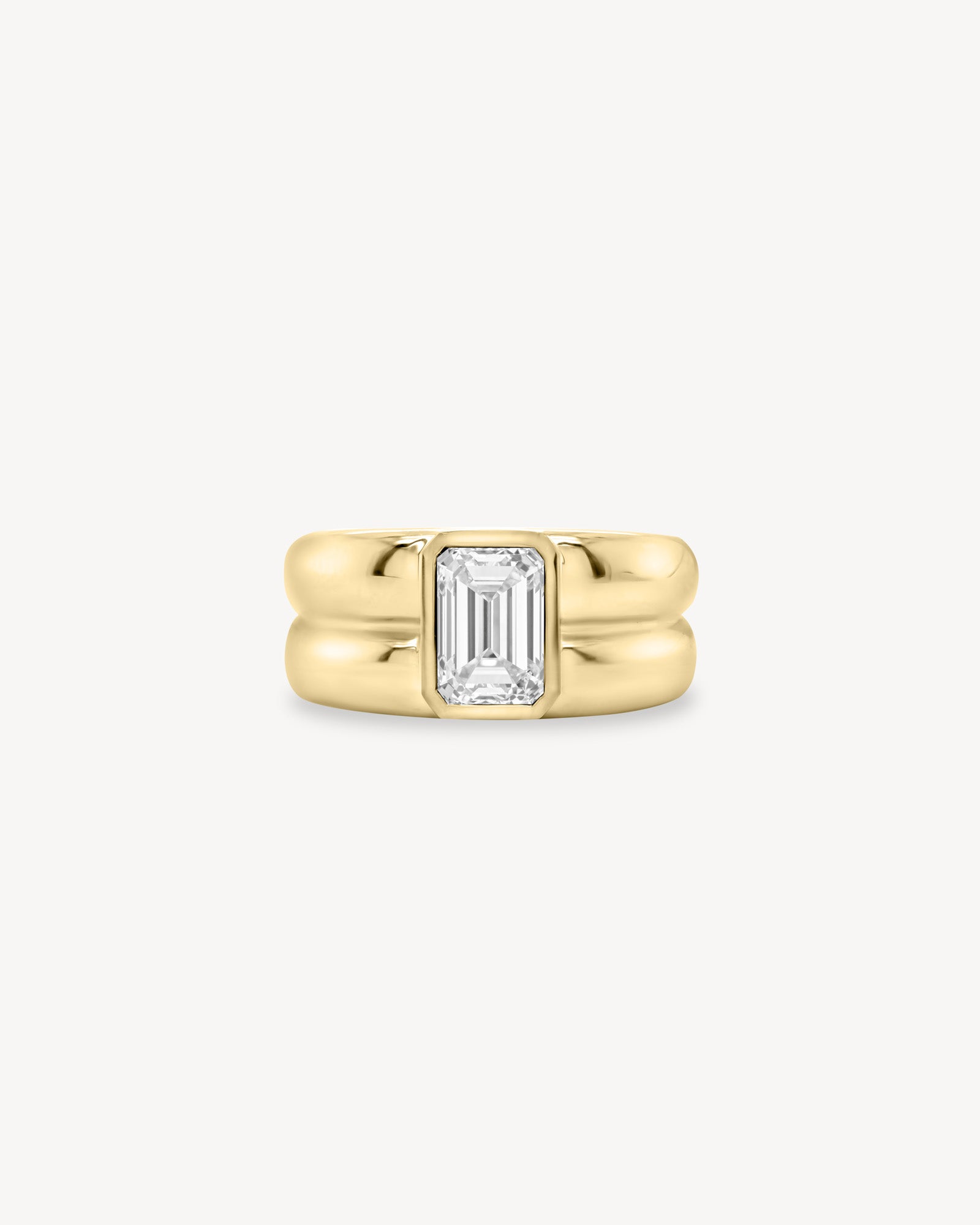 Emerald Cut diamond double gold band ring in 18K yellow gold set against a white background