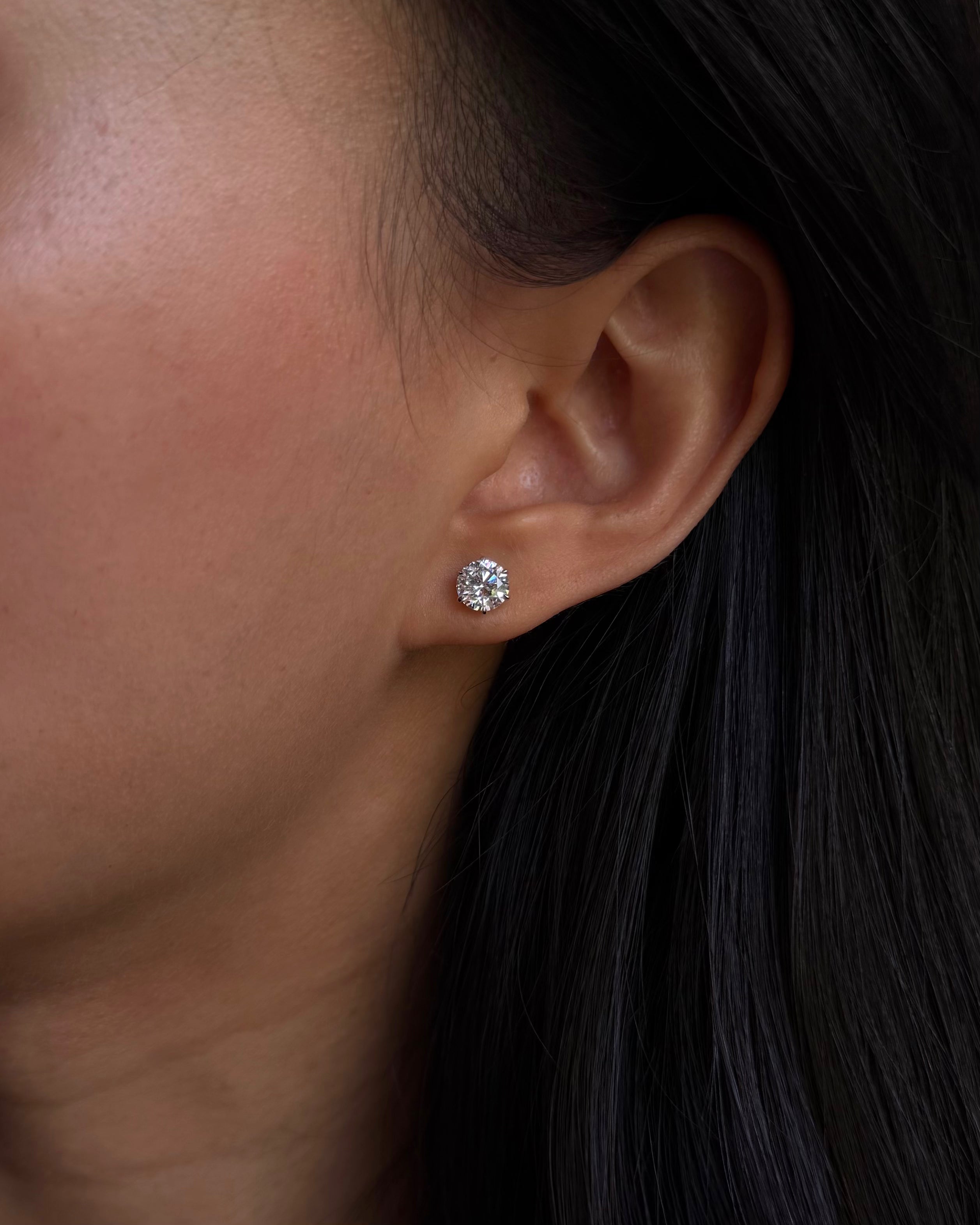 Round cut diamond solitaire six-prong stud earring in white gold worn on ear – tinxx jewelry