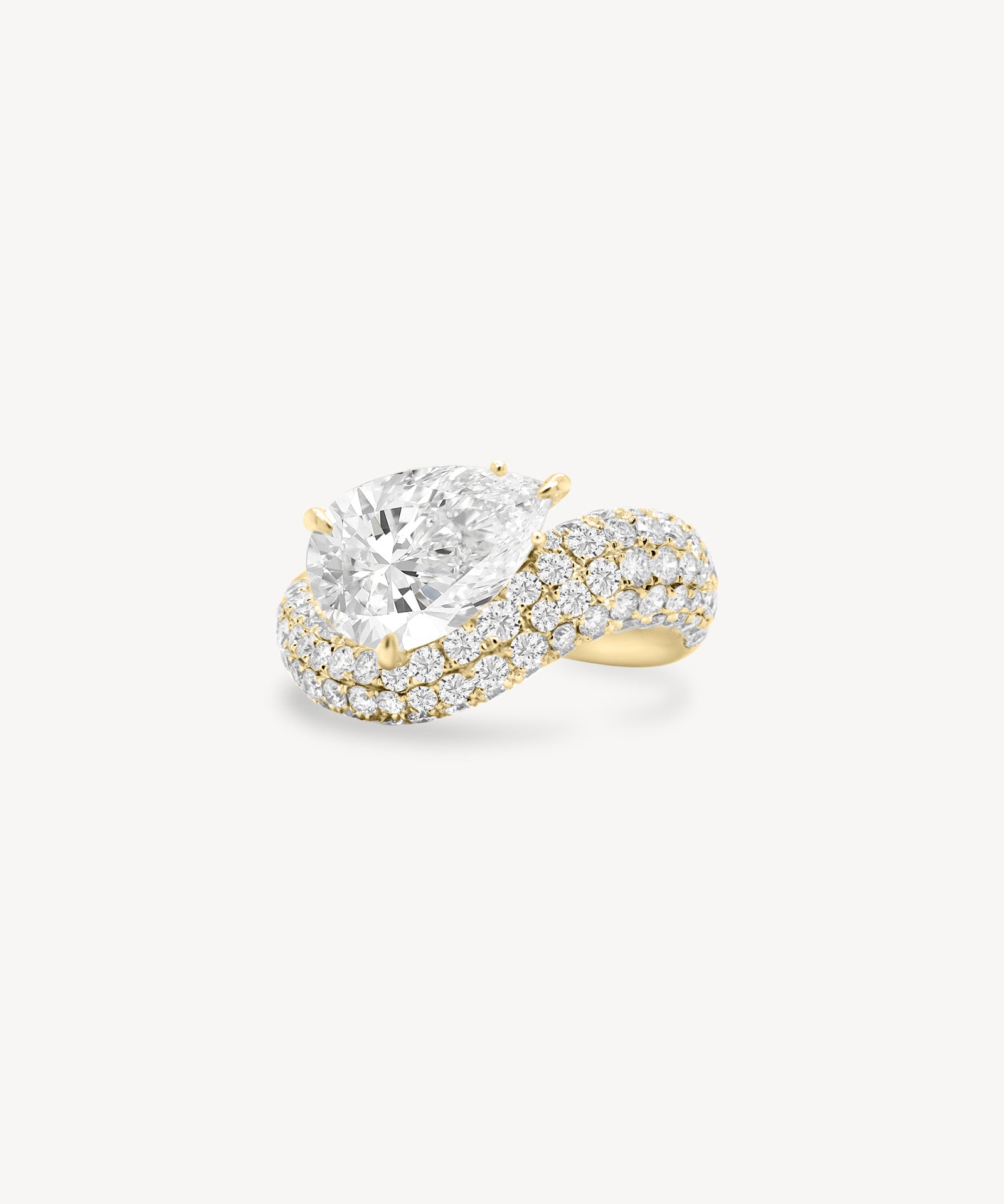 Pear cut diamond wave pavé dome ring in yellow gold