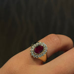 Diamond Signet Ring with a ruby on a pinky finger against a dark background