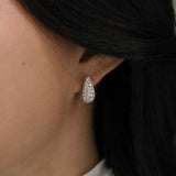 diamond teardrop earrings on ear with pavé setting in bridal styling