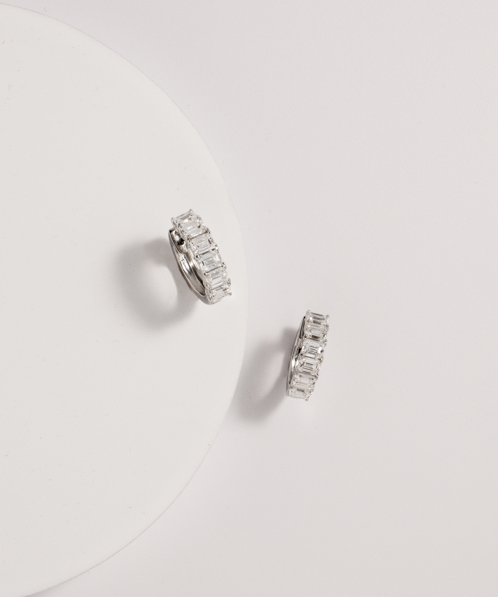 emerald diamond hoops against white background