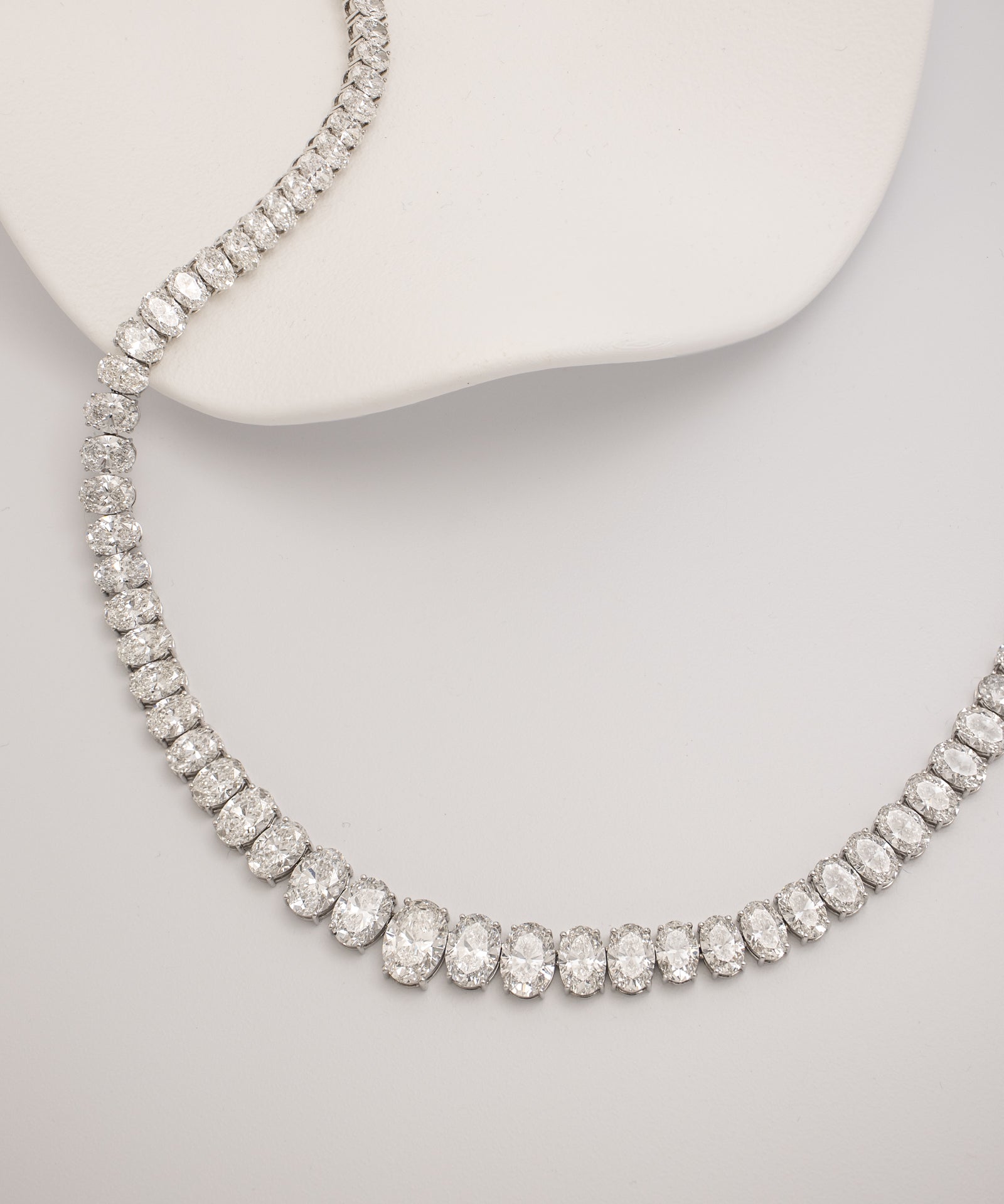 Graduated oval cut diamond tennis necklace in white gold worn on neck – tinxx jewelry