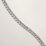 Oval cut diamond tennis bracelet in four-prong setting in white gold, close-up detail