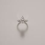 Pear cut diamond solitaire ring in knife edge setting in white gold on a soft neutral background – tinxx jewelry