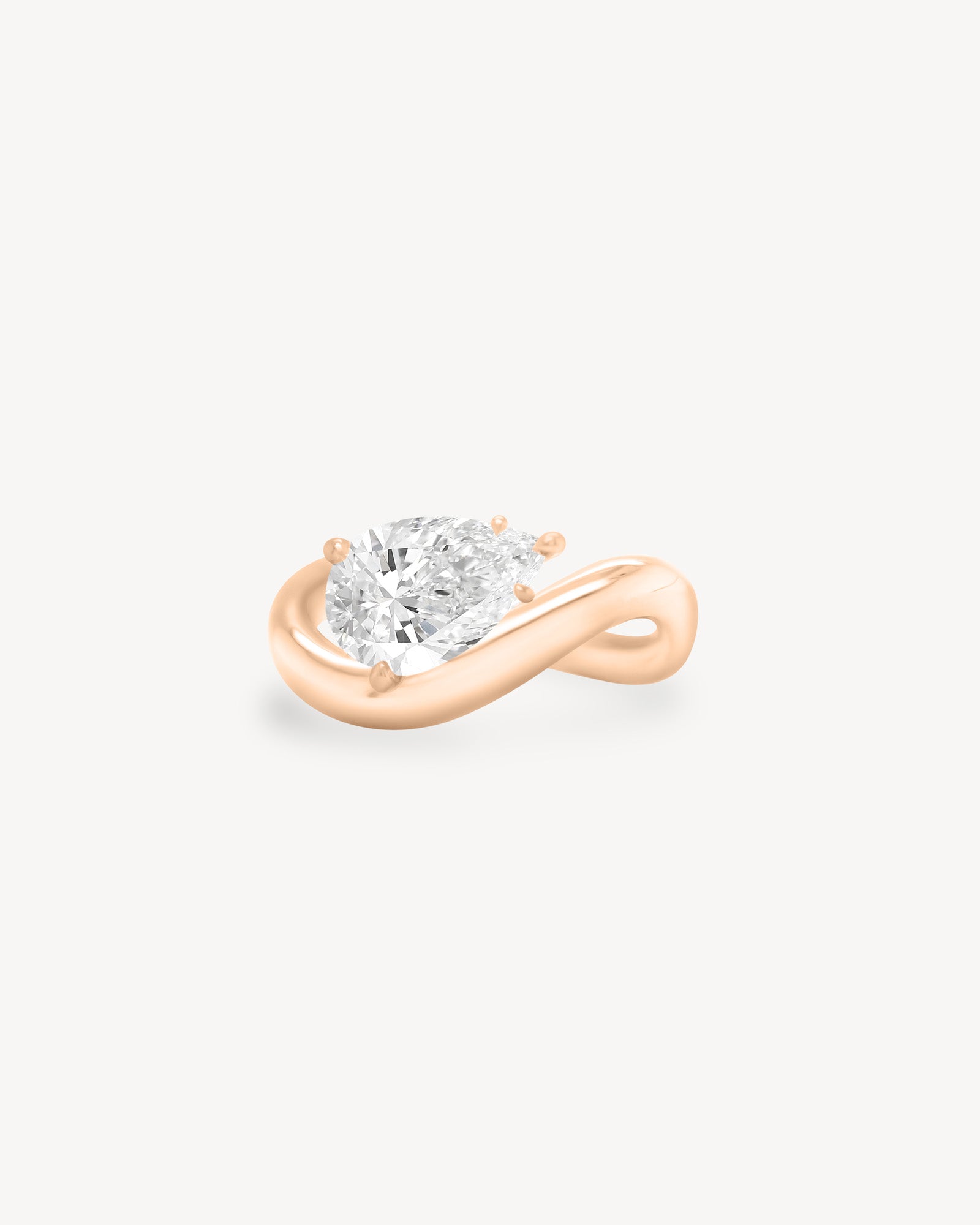 a pear diamond wave band engagement ring in 18K rose gold set against a white background