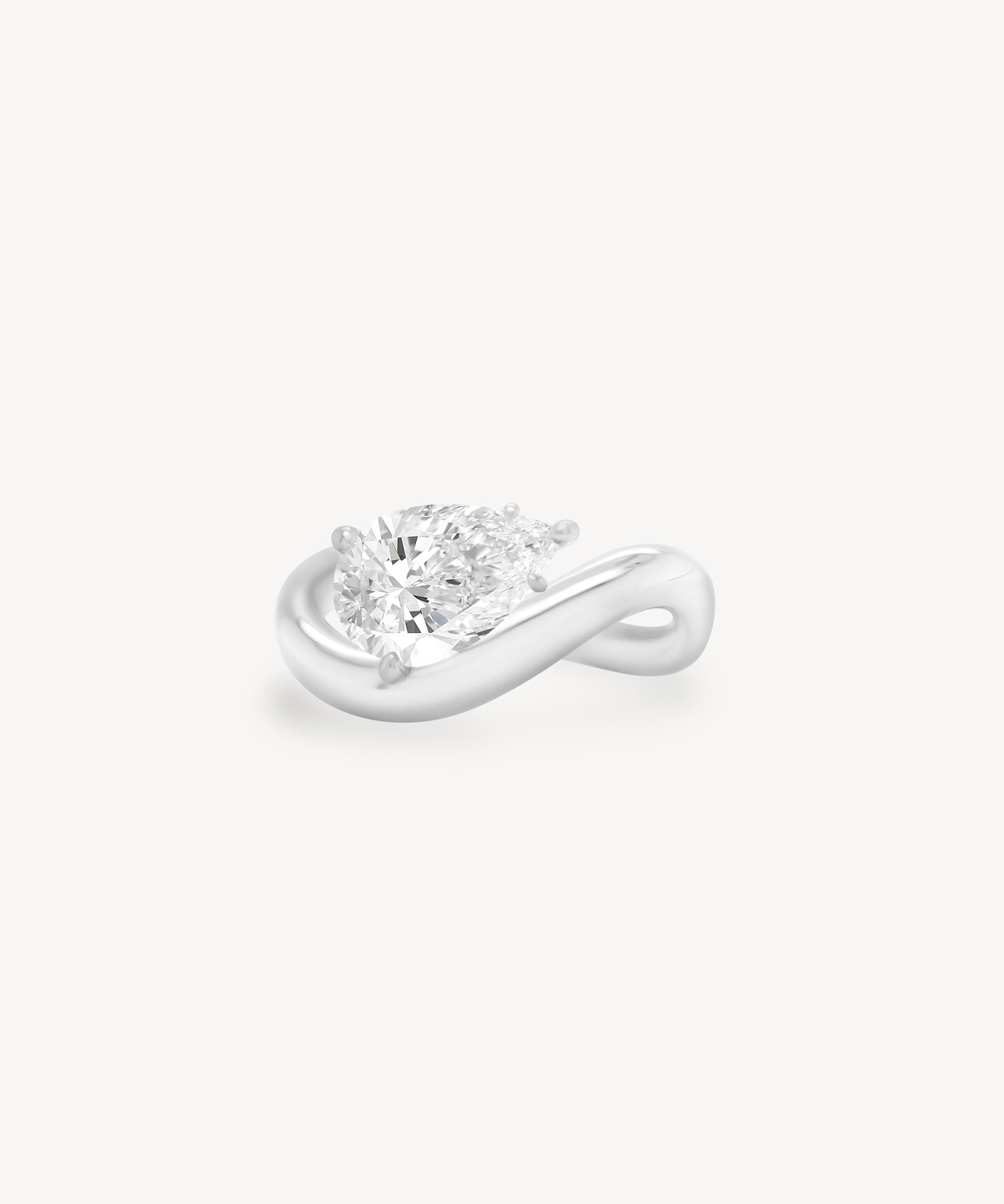 a pear diamond wave band engagement ring in 18K white gold set against a white background