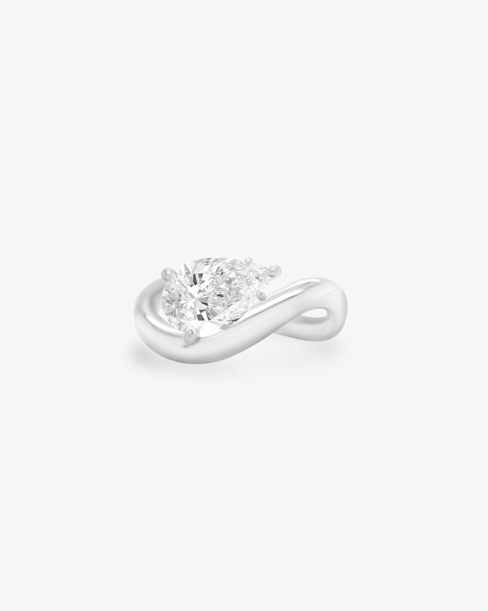 a pear diamond wave band engagement ring in 18K white gold set against a white background