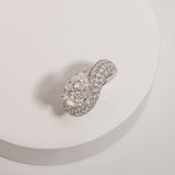 Pear cut diamond wave pavé dome ring in white gold, styled on a sculptural stand