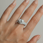 Pear cut diamond wave pavé dome ring in white gold worn on hand