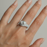 Pear cut diamond wave pavé dome ring in white gold worn on hand