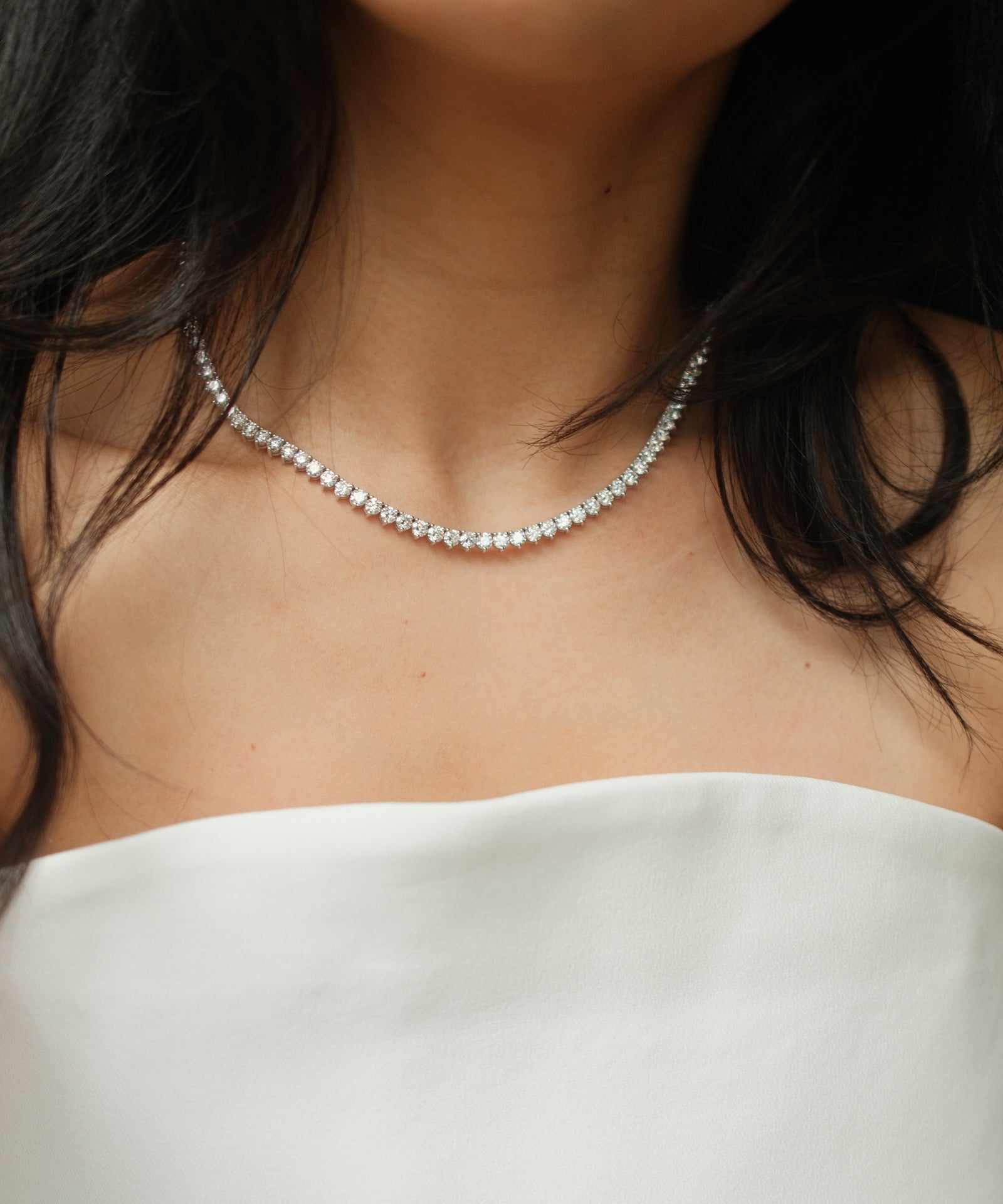 Round cut diamond tennis necklace in scalloped three-prong setting worn on neck, in white gold – tinxx jewelry
