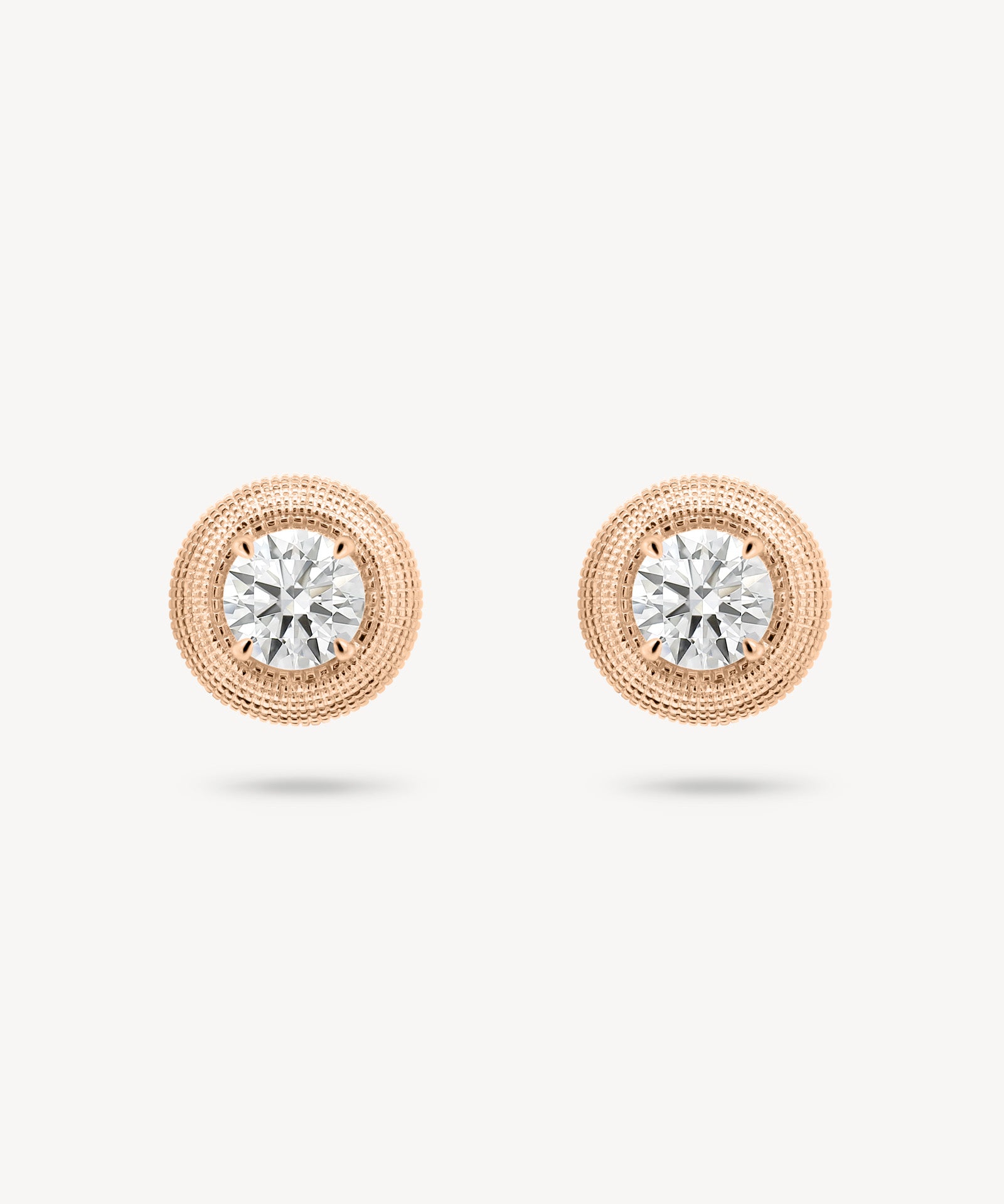 Round cut diamond stud earring with textured gold surround in rose gold