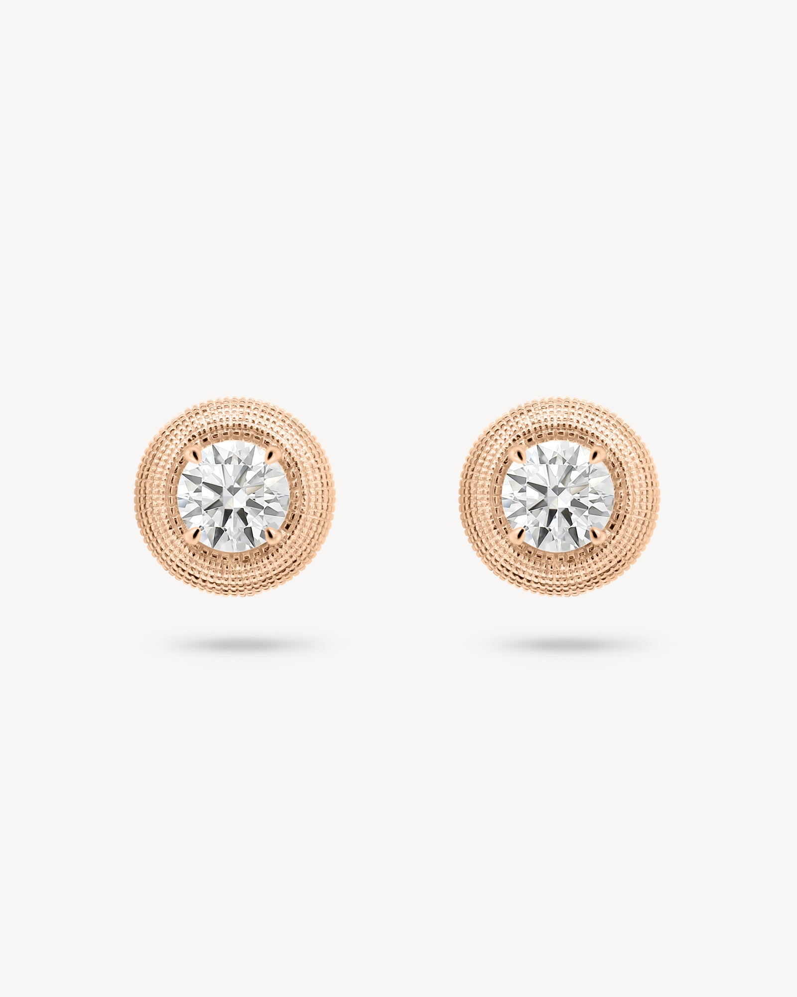 Round cut diamond stud earring with textured gold surround in rose gold