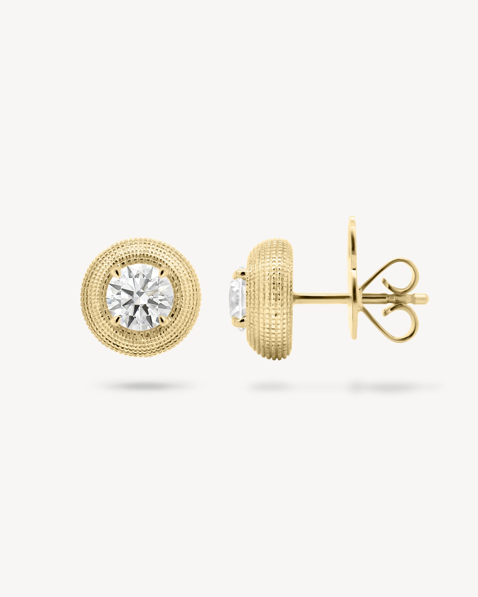 Round cut diamond stud earring with textured gold surround in yellow gold, front and side view