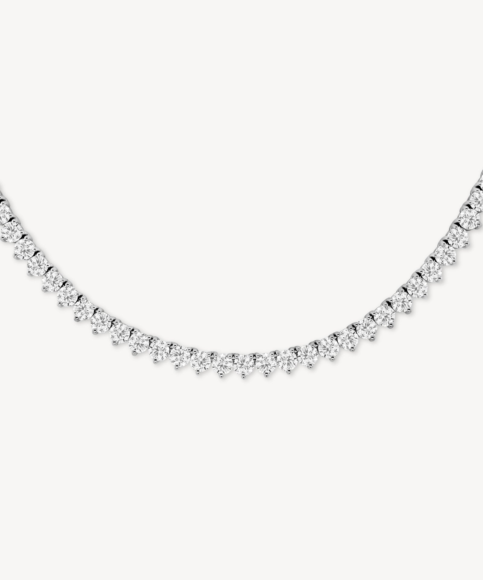 Round cut diamond tennis necklace in scalloped three-prong setting in white gold