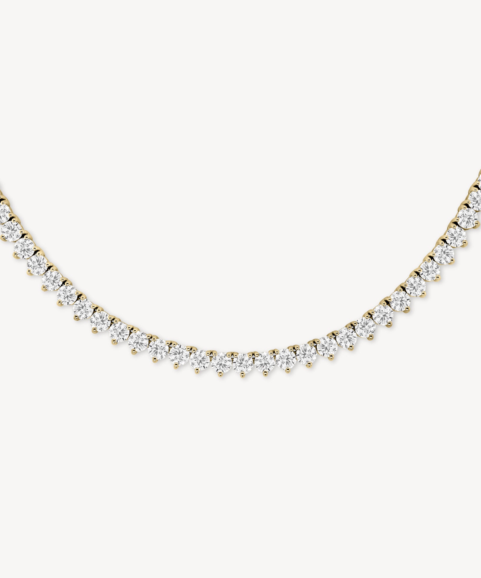 Round cut diamond tennis necklace in scalloped three-prong setting in yellow gold