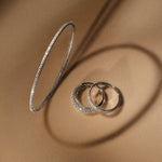 tinxx diamond pavé bangle and rings on a brown surface