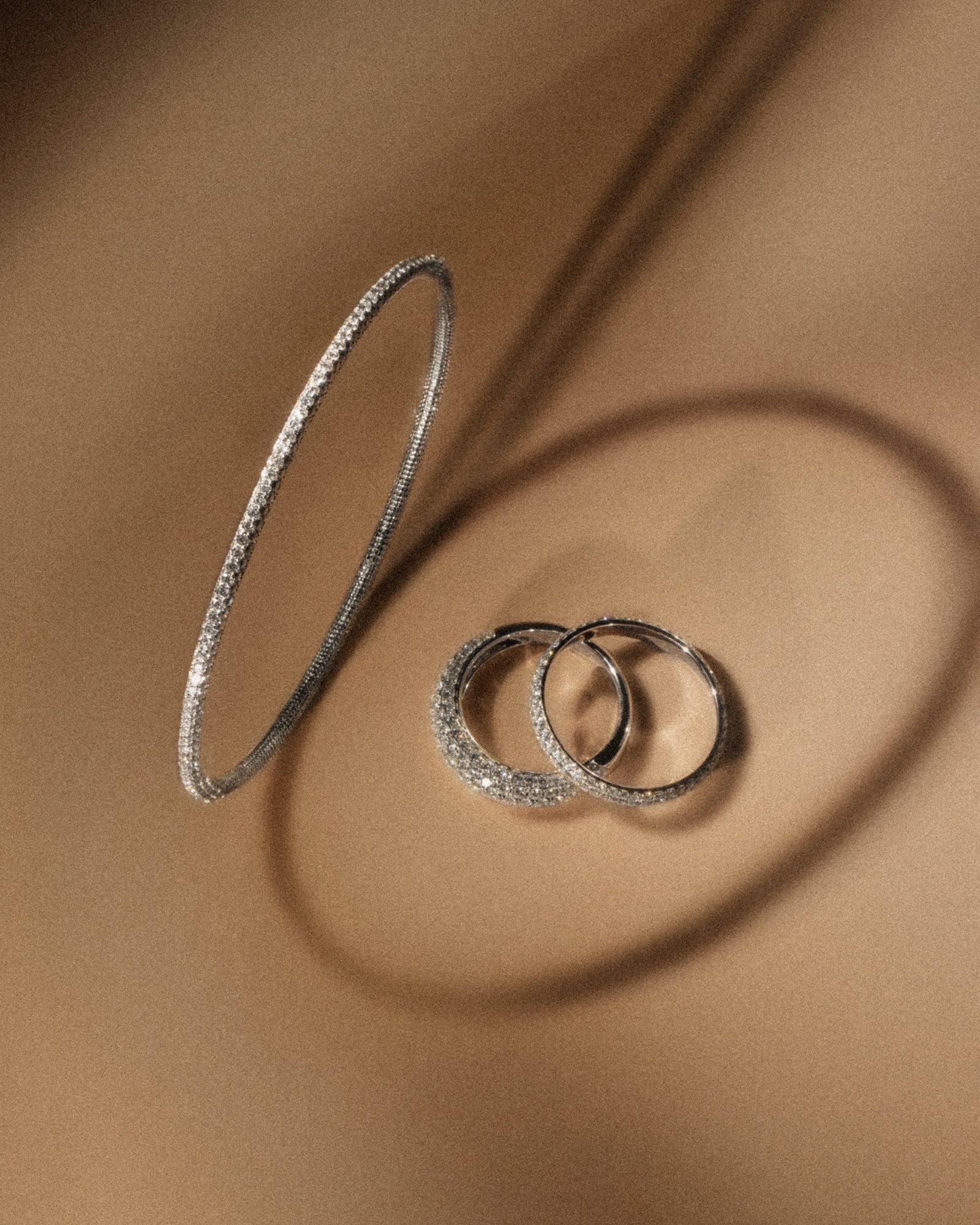 tinxx diamond pavé bangle and rings on a brown surface