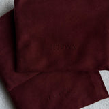Red suede fabric jewelry pouch with 'tinxx' logo debossed