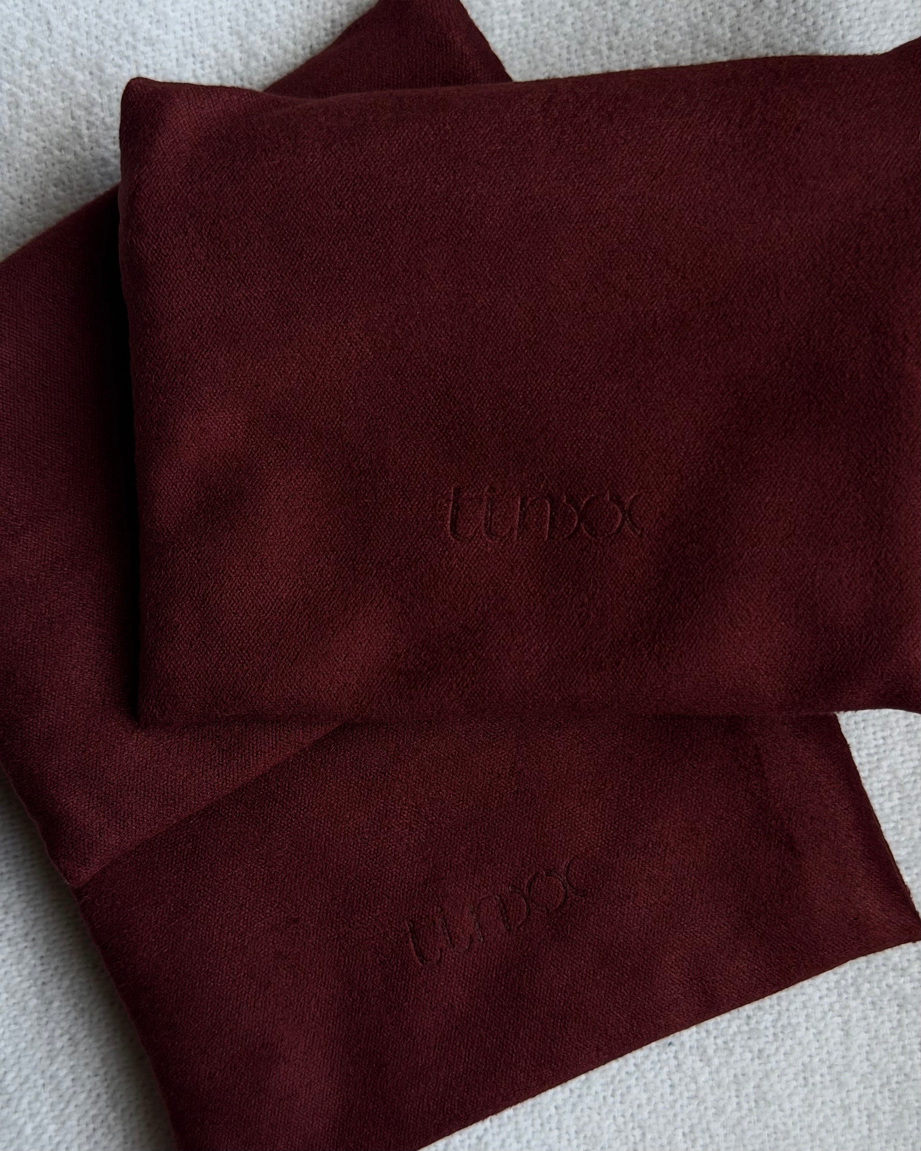 Red suede fabric jewelry pouch with 'tinxx' logo debossed
