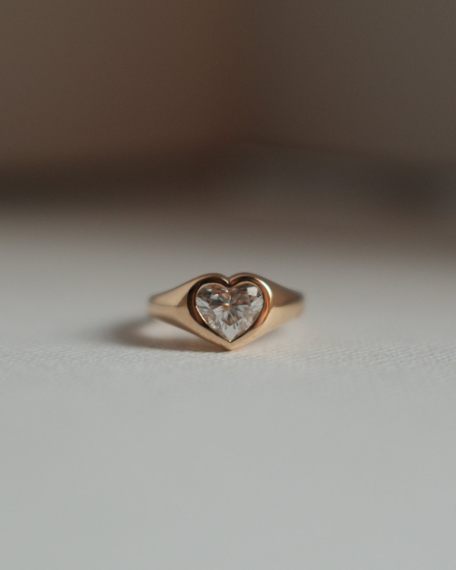 Front view of a 18K yellow gold heart shaped diamond signet ring