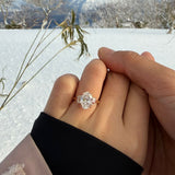 Two hands holding each other with a tinxx jewelry diamond ring against a snowy landscape.