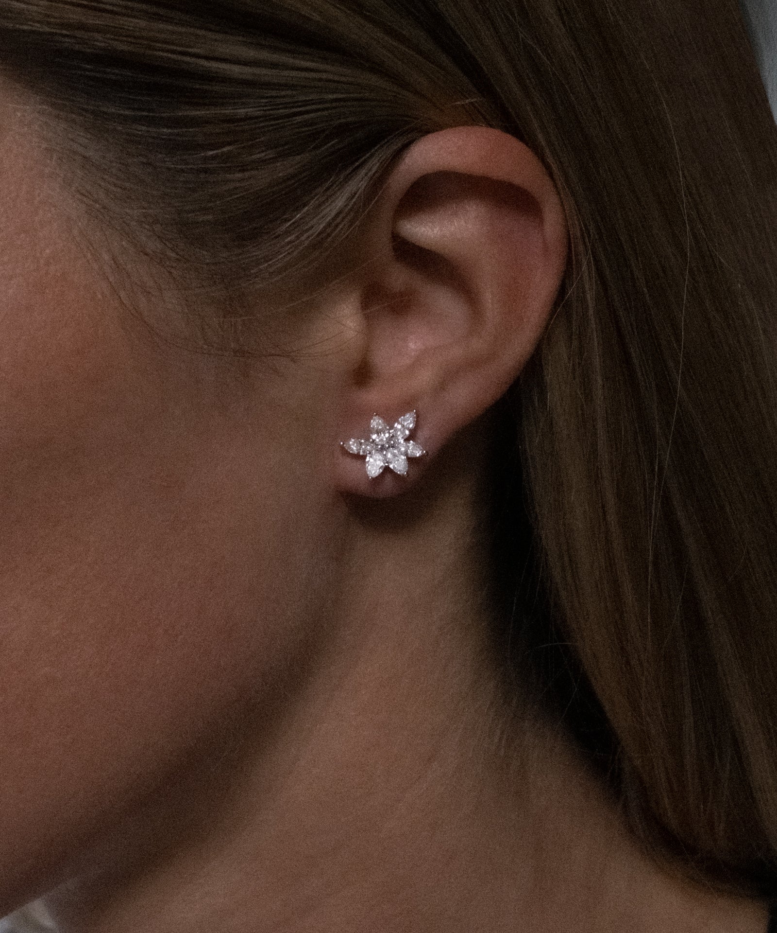 Marquise and pear cut cluster lab grown diamond stud earrings in 18K white gold from tinxx, shown worn on ear.