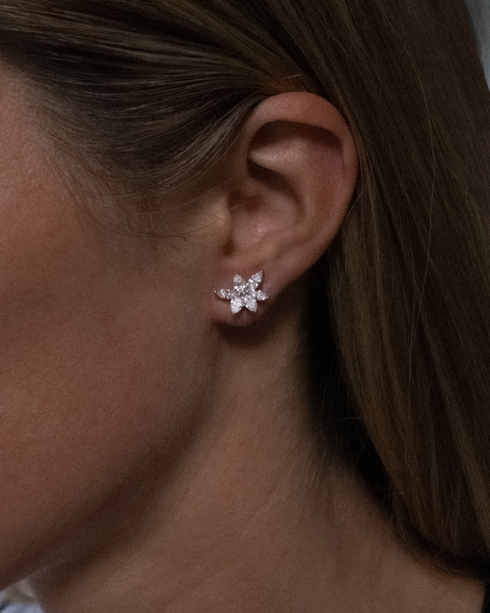 Marquise and pear cut cluster lab grown diamond stud earrings in 18K white gold from tinxx, shown worn on ear.